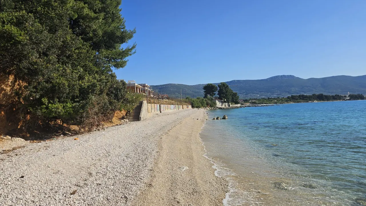 Photograph, May 2026 — The beach below the estate